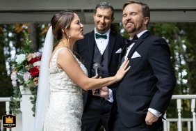 At Georgia Palms in Austell, Georgia, the bride reacts emotionally to the groom's vows, her expression revealing tenderness and surprise during the ceremony as guests nearby look on.